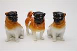 A set of three Austrian porcelain figures, each modelled as a pug dog in various poses, each 6.5" (