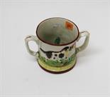 A STAFFORDSHIRE RELIEF MOULDED LOVING CUP,
with dog and pheasant in relief, the interior with a