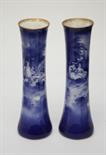 A TALL PAIR OF ROYAL DOULTON BLUE AND WHITE VASES,
each of flared form decorated in transfer with