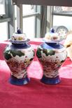 A PAIR OF CHINESE FAMILLE VERTE BALUSTER SHAPED PORCELAIN URNS AND COVERS, each decorated
all around