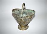 A PIERCED AND MOULDED BRASS HELMET SHAPED COAL BUCKET
with arched and leaf cast brass handle, the