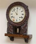 A VERY ATTRACTIVE CARVED WALNUT BRACKET TYPE WALL CLOCK,
19th century, with two train movement,