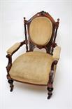 A VICTORIAN WALNUT OPEN ARMCHAIR
the arched top with a cartouche crest above an oval padded panel