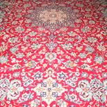 A PERSIAN KNOTTED CARPET, 
the red ground with a floral field and a central medallion, 12ft9in (