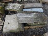 A COLLECTION OF CUT LIMESTONE AND GRANITE ITEMS, including some pillar cap flags and a cornice