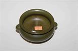 A SPINACH GREEN GROUND CIRCULAR OGEE SHAPED STONEWARE BOWL 
with two mask handles and an impressed