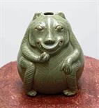 A CHINESE LIGHT GREEN GLAZED POTTERY FIGURE, 
of a seated mythical animal, 6in (15cm). (1)