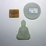 A SMALL CARVED JADE BUDDHA,
2.5in (7cm), a jade disc and a small pendant. (3)