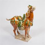 A CHINESE POTTERY FIGURE OF A SADDLED HORSE, 
Tang style, with head held high, facing to the