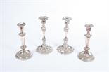 A PAIR OF VICTORIAN SILVER PLATED CANDLESTICKS, 
each with baluster and leaf cast stem on conforming