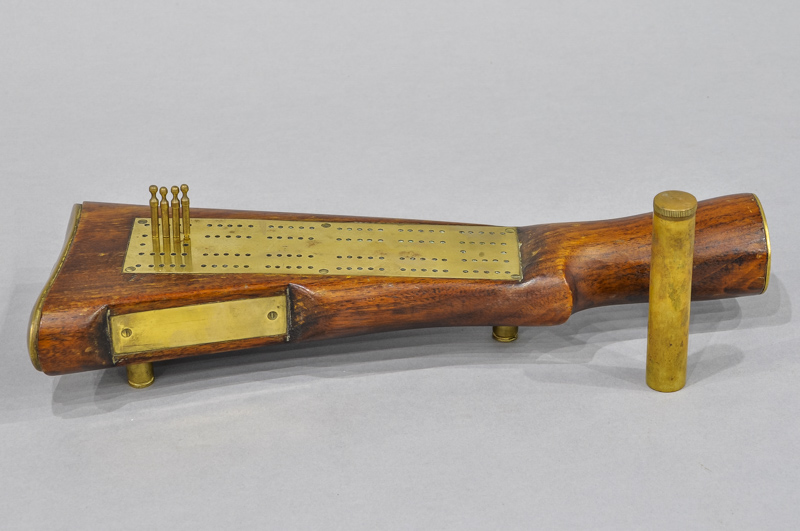 Cribbage board made from a rifle stock with `bullet legs`, brass board