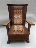 An American Arts and Crafts oak framed armchair.
Trapezoid shaped back, with carved floral panels,