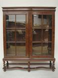 A late Victorian late 17th century style walnut glazed bookcase on stand. The upper section with two