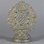 AN ALTAR ORNAMENT: Mongolia, 19th century silver repousse, silvered copper base, inlaid with coral,