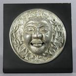 A ROUNDEL DEPICTING A MAN`S FACE: Tibet, c.18th century tinned copper, probably part of a cabinet