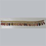 A TEMPLE HANGING: Tibet, 19th century Composed of a row of 28 Tsaklis mounted on cloth each