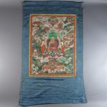 A THANG-KA DEPICTING BUDDHA: Tibet, 19th century Pigment with gold on cloth, silk mount, seated on