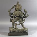 A LARGE BRONZE FIGURE OF MAHAKALA: Tibet, 18th century Stepping to the right on a demon, on a