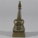 A SMALL BRONZE STUPA, Tibet, circa 17th century The flared bell-shaped body with inscribed niche on
