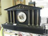 Monumental black slate mantle clock, 4" dial to the centre flanked by 6 Corinthian brass columns,