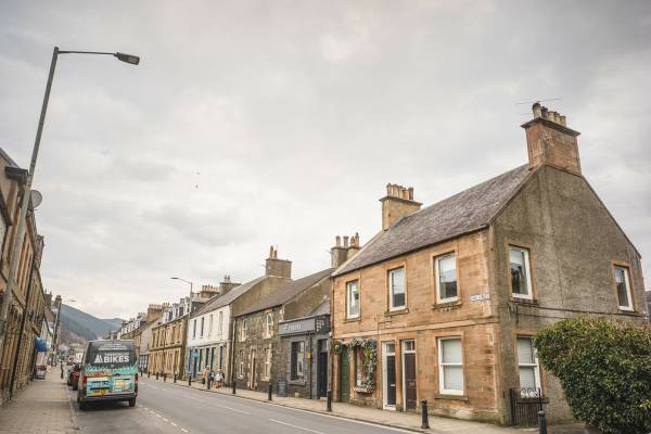 Image of John Buchan (1875-1940) was born in Perth and spent his childhood holidays at his grandparents’ house in Tweeddale, in the South of Scotland. This area had no small impact on Buchan – indeed, in 1935, after his election to the House of Lords, he took the name Lord Tweedsmuir. 

He was a prolific author, writing 130 books in total and contributing to a further 150, as well as producing essays, poems, articles, reviews, and journalism. His most famous works featured the character Richard Hannay, e.g. ‘The Thirty-Nine Steps’. 

Despite an international reputation and a life spent travelling Africa, Europe and North America, Buchan remained devotedly attached to Scotland. In his poem 'The South Countrie', as well as in many other works, he goes further, preferring the South of Scotland to every other part of Scotland. 

Don't forget to:
Check walk the John Buchan Way from Peebles to Broughton.
Or to visit Dumfries and Galloway - stay at Knockinaam Lodge where Buchan was a guest. The stream that runs past the lodge was the inspiration for the House that Hannay fled to away from the police in 'The 39 Steps'. 
Buchan explored Galloway and spent a lot of time cycling, covering 65 miles of the hills in 24 hours in 1897. Three novels (Dickson McCumm trilogy) and 1 short story are Galloway set. In Buchan's landscape "Portaway" is Newton Stewart, "Gledmouth" is Dumfries, "Castle Gay" is the Castle of Old Risk and "Fallatown" is Wigtown, as well as the district of Carrick in Galloway where the action for 'Huntertower' took place.