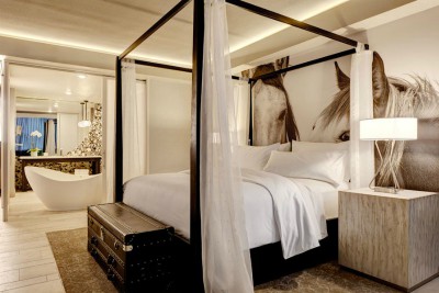Archer Hotel Austin master bedroom with four poster bed and horse photo