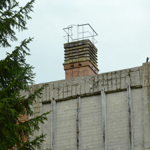 Smokestack and processing plant facade. Construction made of reinforced concrete was covered by insulating wooden layer. 