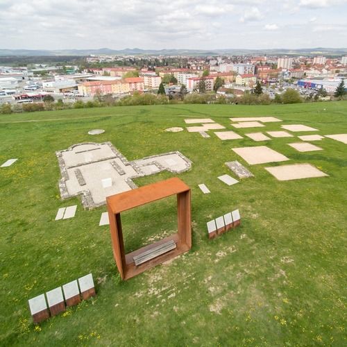 Rekonstrukce základů kostela s přilehlými hroby a půdorysy sídlištních staveb. 