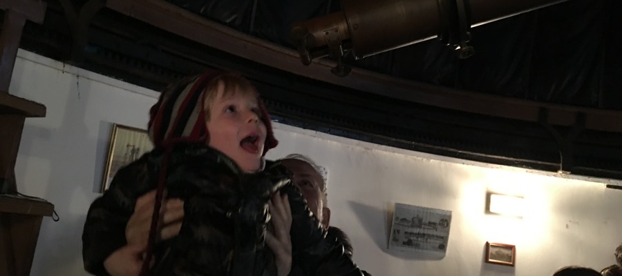 A young boy looking through the telescope at our real-working observatory