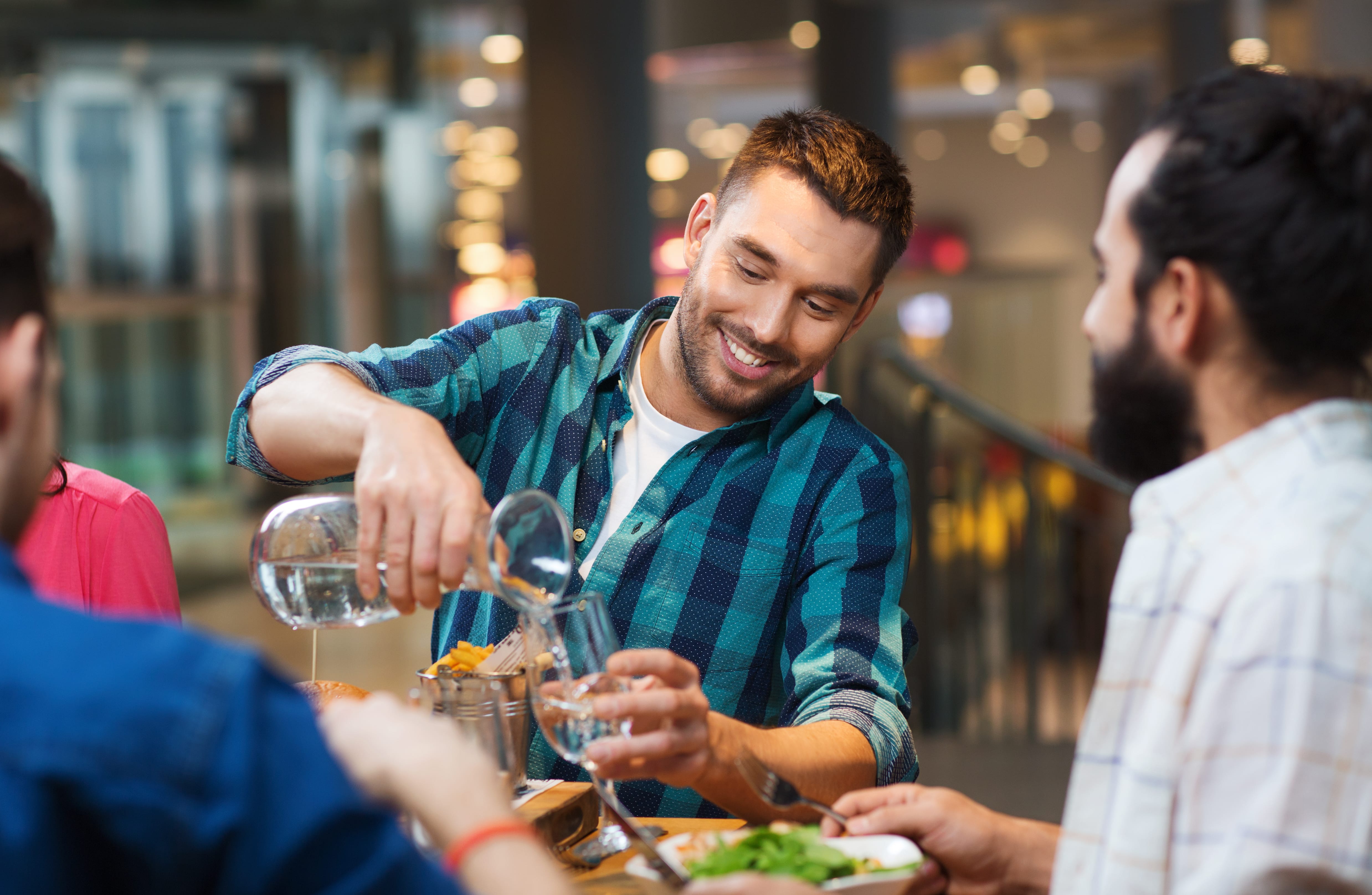 Man pouring water at restaurant