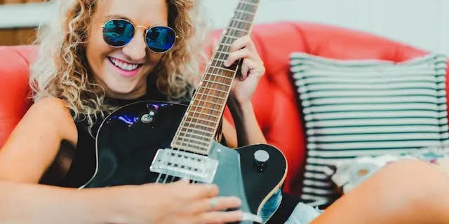 Trendy girl playing guitar