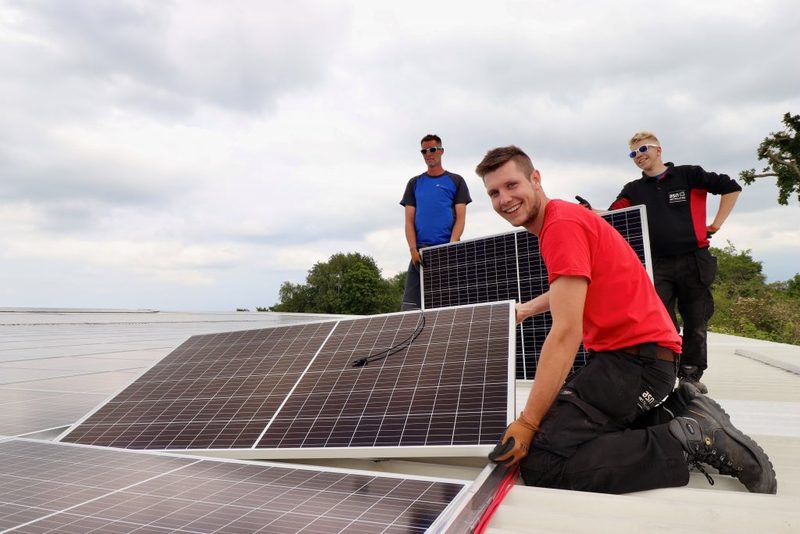 Medewerkers van ASN Installaties leggen de laatste panelen op het dak.