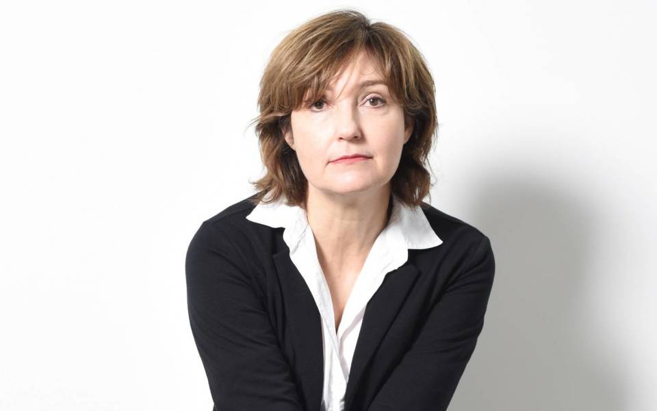Viv Albertine, wearing a white shirt and black suit jacket.