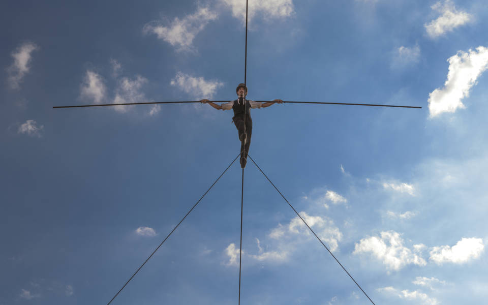 A man walks across a high tight-rope