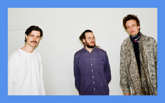 Three men stand casually against a white background