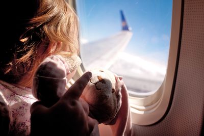 Little girl on aeroplane with teddy