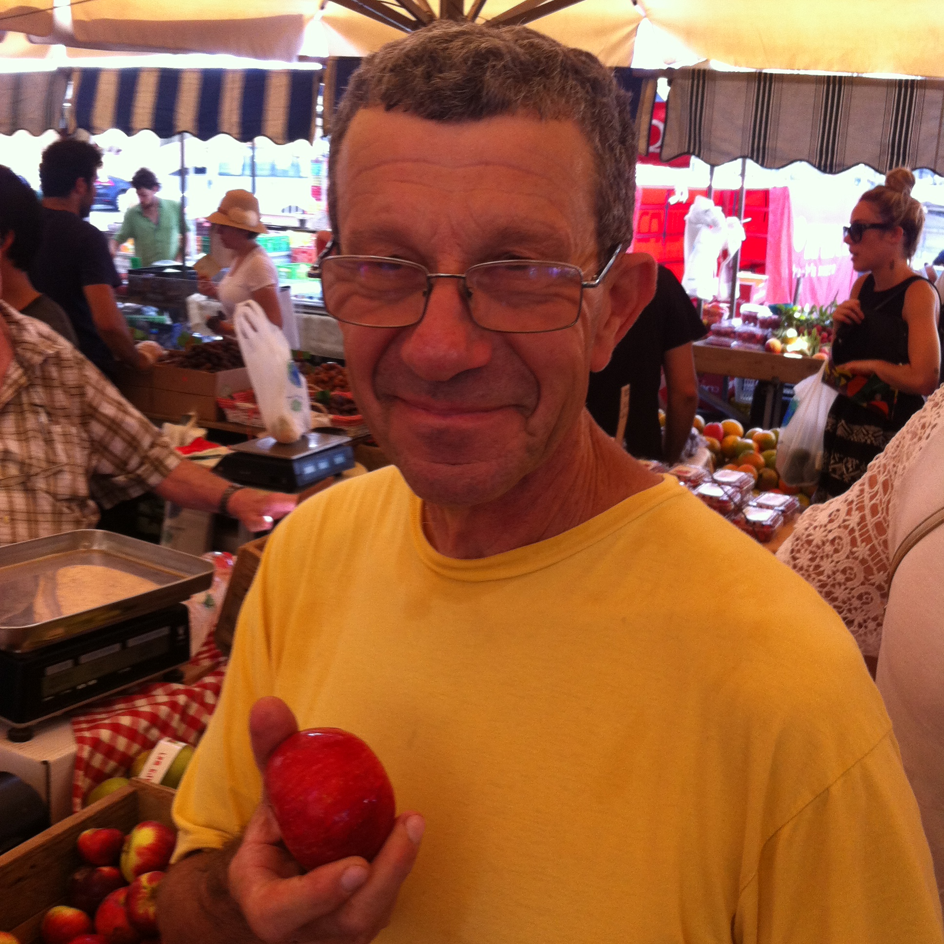 Amiel holds a Japanese apple at the Tel-Aviv farmer