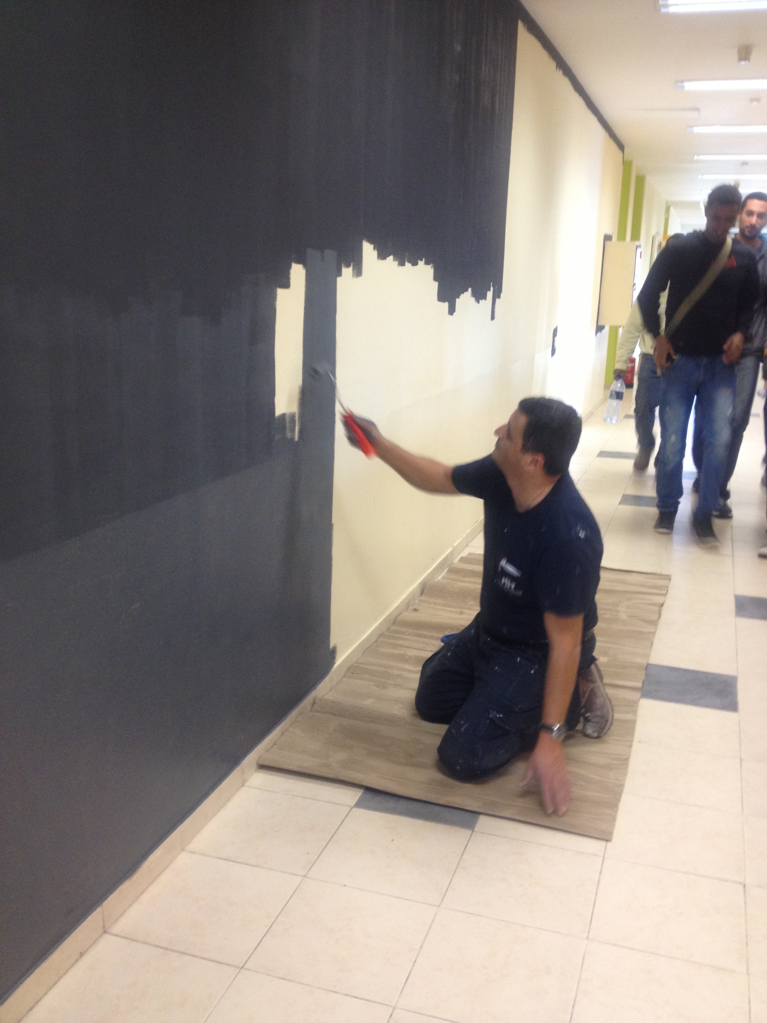 קובי צובע את קיר המגנטים הגדול בחמש שכבות של צבע מגנטי
