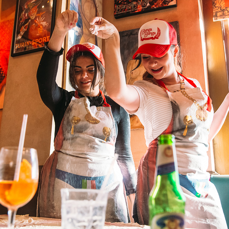 Photograph: Two girls sprinkling flour on pizza dough