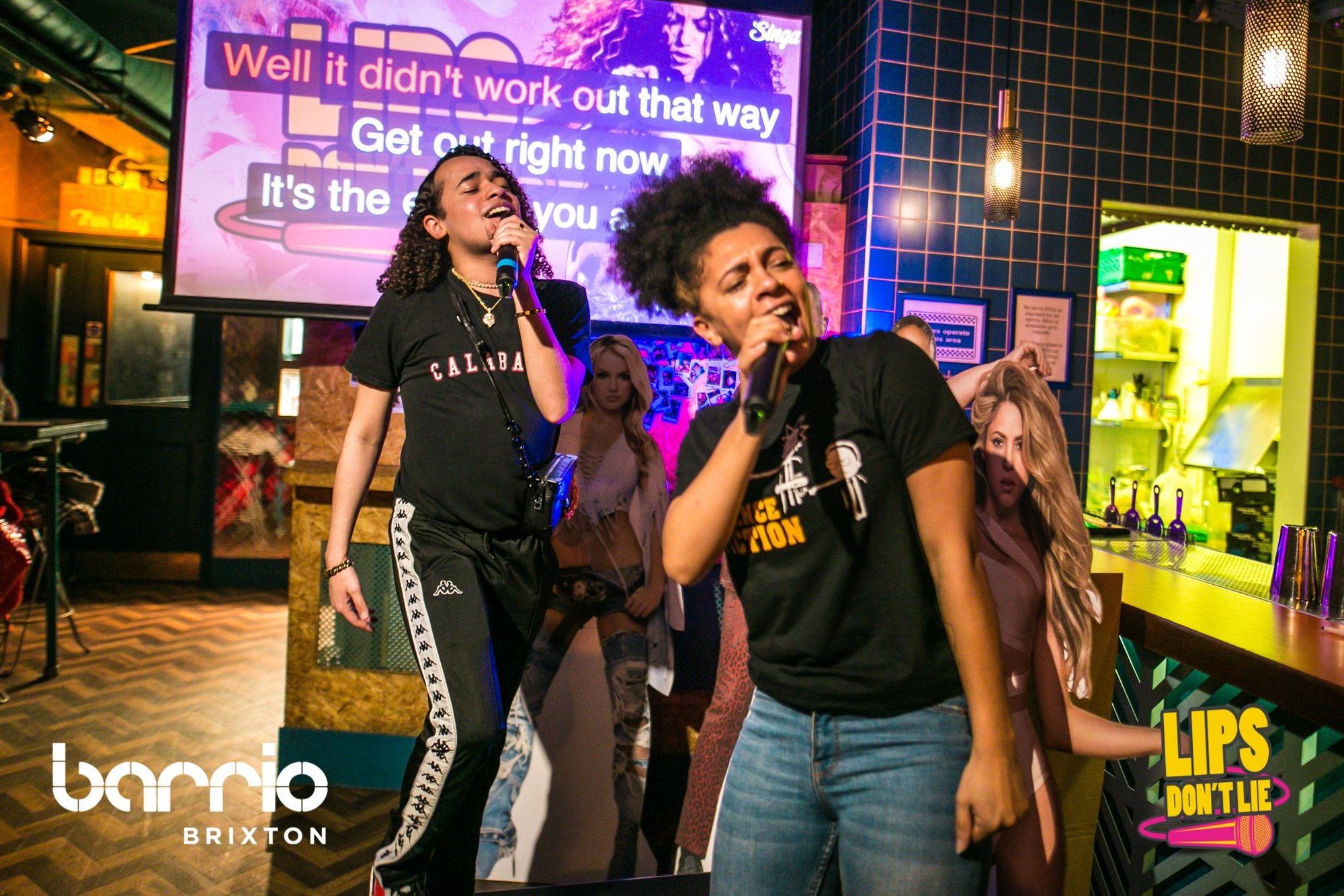 two singers singing karaoke at barrio brixton