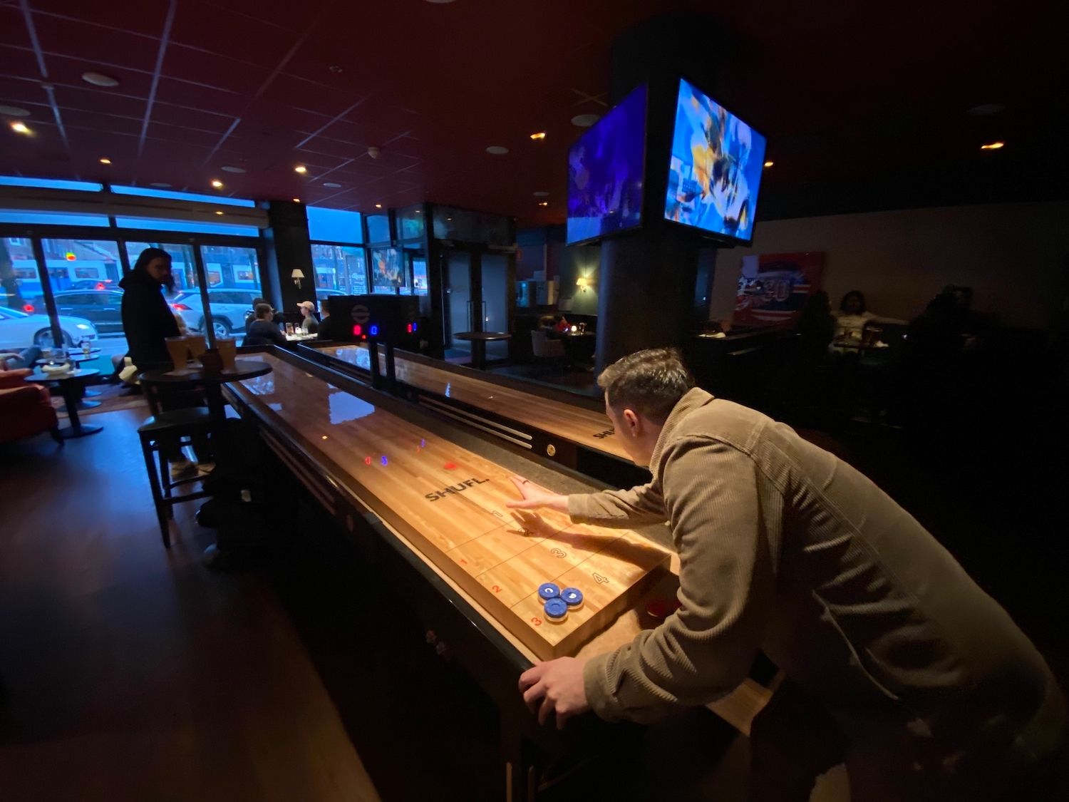 Customers playing shuffle board at a bar, O'Learys Järntorget.