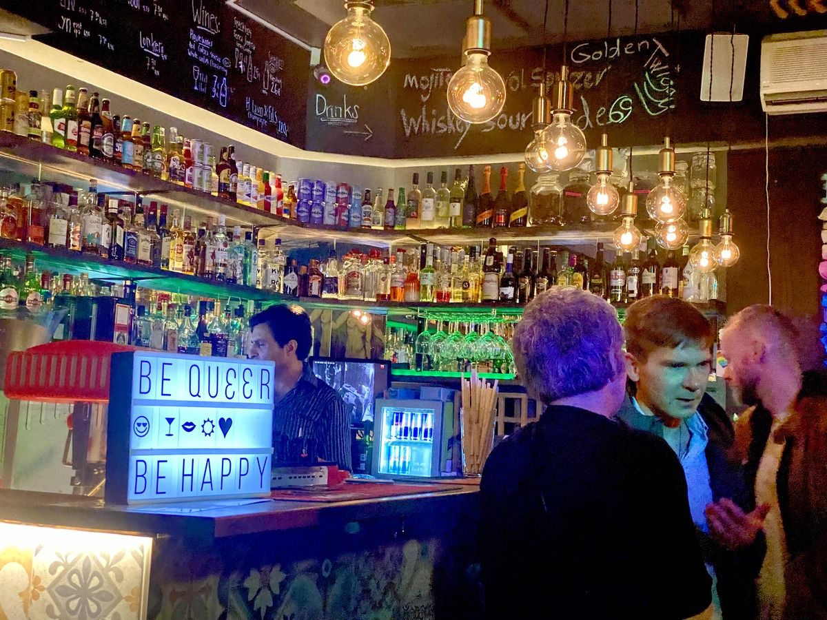 The bar area in Street Pride Helsinki, showing a sign to customers that reads "Be Queer, Be Happy"