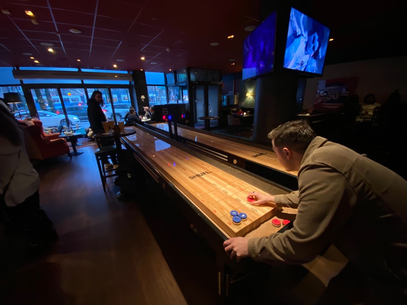 människor spelar shuffleboard