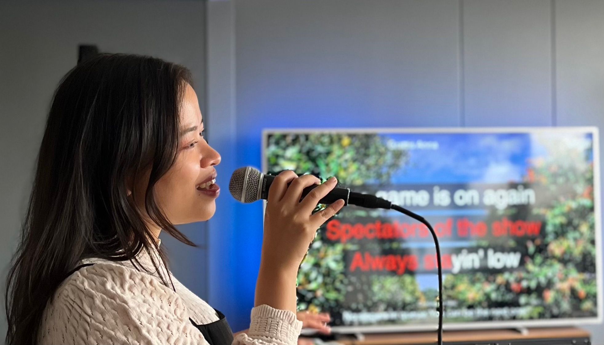 Woman singing karaoke at home using the Singa karaoke app.