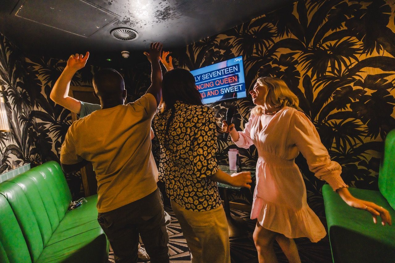 Group singing in the karaoke room at All Star Lanes. - Singa