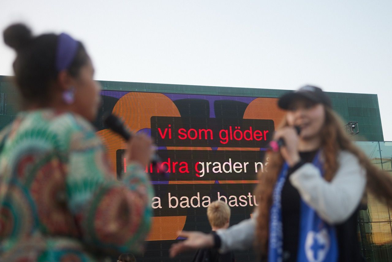 Two women singing karaoke in Swedish.