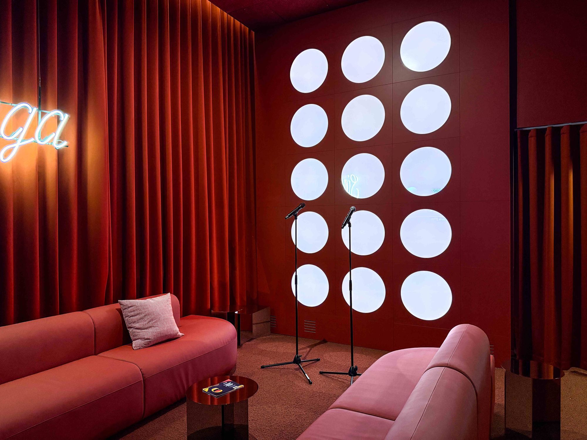 Singa-Karaoke-Raum mit Wandbeleuchtung, Sofas und Mikrofonen