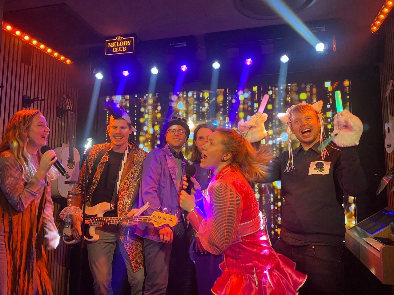 Karaoke-Spaß in einem Karaoke-RAum. Fünf kostümierte Menschen singen Karaoke.