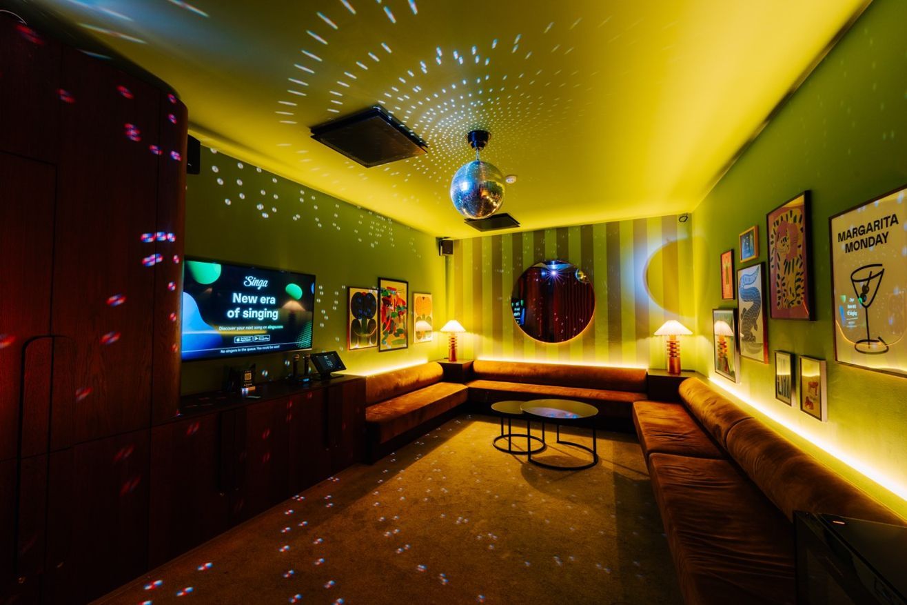 Geräumiger Karaoke räum mit Sitzgelegenheiten an den Seiten, Party-Beleuchtung und coolen Farben.