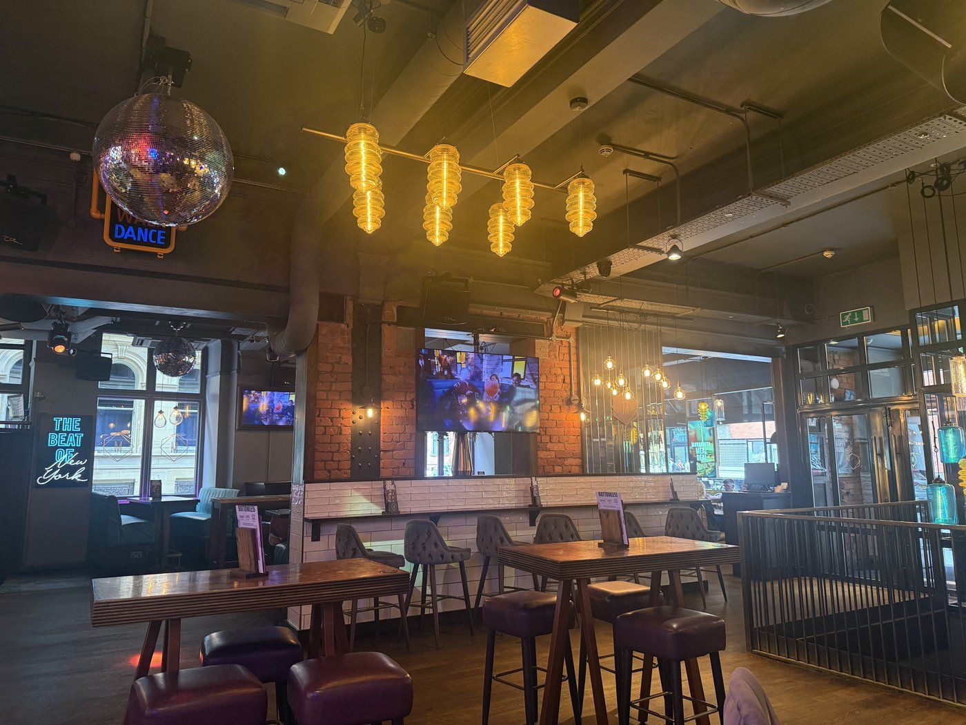 A private karaoke room at Manahatta — purple-lit, disco ball, intimate booth seating